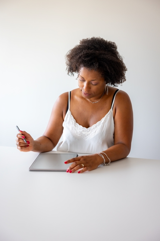 Marjorie en train de travailler, avec un haut et un fond blanc