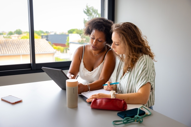 Marjorie en train de travailler, avec un haut et un fond blanc